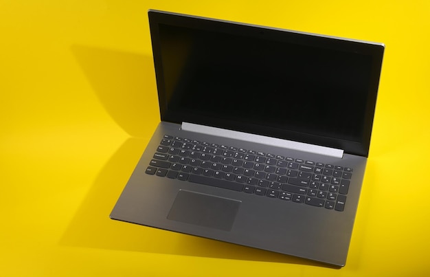 levitating modern laptop on yellow background