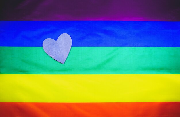 Lgbt community colorful flag. Wooden heart on rainbow background. Lesbian and gay problems. Legalization of marriage for couple with homosexual orientation.