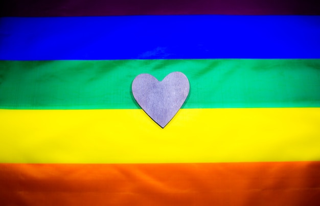 Lgbt community colorful flag. Wooden heart on rainbow background. Lesbian and gay problems. Legalization of marriage for couple with homosexual orientation.