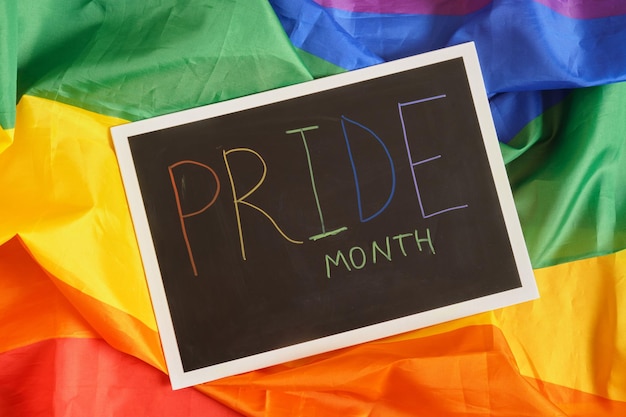 LGBT Pride Month in June inscription pride on black board on lgbt flage