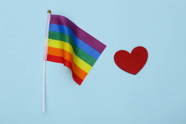 LGBT rainbow flag and red heart on blue background. Love has no gender. Tolerance, freedom