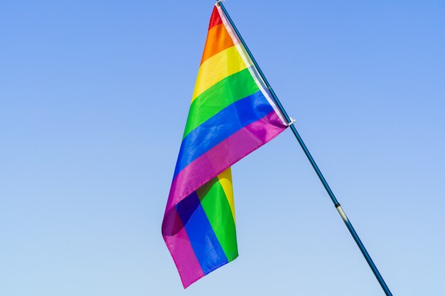 LGBT waving flag in the sky on flagpole