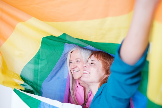 Lgtbi senior couple with the pride flag and claiming their sexuality Concept pride rainbow symbol