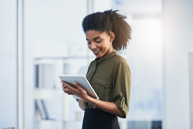 Life made easier with the touch of a button Shot of a young businesswoman using her digital tablet in a office