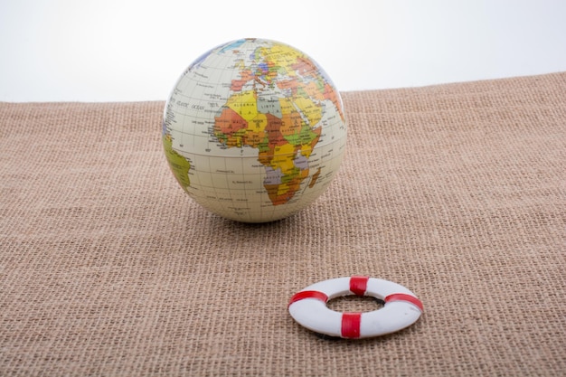 Life preserver beside a globe on canvas