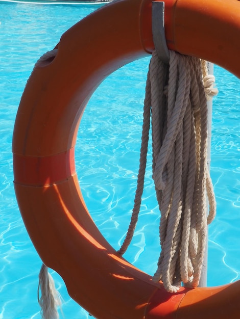 A life preserver hangs from a rope in a pool.