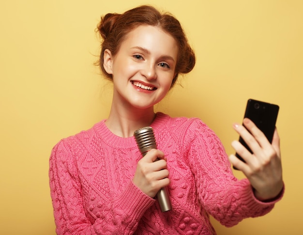 Life style happiness emotional and people concept beauty girl with a microphone singing and take selfie