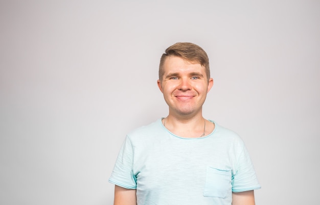 Life style and people concept - Happy handsome young man wearing blue t-shirt over white background