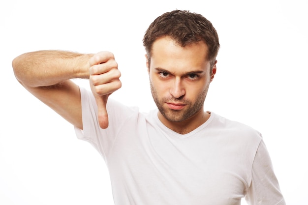 Life style  and people concept: young casual man making the thumbs down negative hand sign on white background