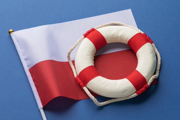 Lifebuoy and Poland flag on a colored background concept on the theme of help