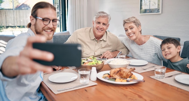 Lifes greatest memories are made in between food and family Shot of a family taking selfies while having a meal together at home