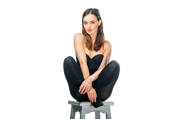 Lifestyle attractive woman posing on white isolated background Young pretty model sitting on the chair