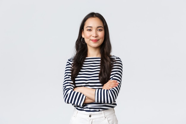 Lifestyle, beauty and fashion, people emotions concept. Confident good-looking young successful woman over white background, smiling and cross arms chest self-assured pose, white background