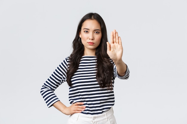 Lifestyle, beauty and fashion, people emotions concept. Serious-looking displeased asian woman tell to stop, extend hand disappointed to prohibit or restrict something bad happening