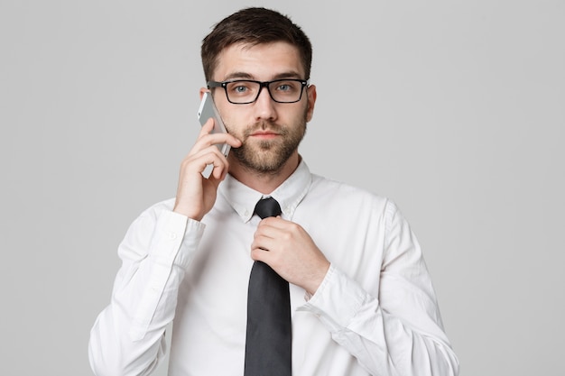 Lifestyle and Business Concept - Portrait of a handsome businessman serious talking with mobile phone. Isolated White background. Copy Space.