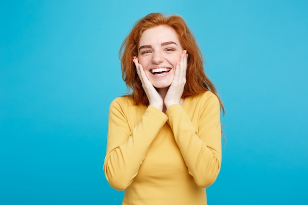 Lifestyle concept - Portrait of cheerful happy ginger red hair girl with joyful and exciting smiling to camera. Isolated on Blue Pastel Background. Copy space.