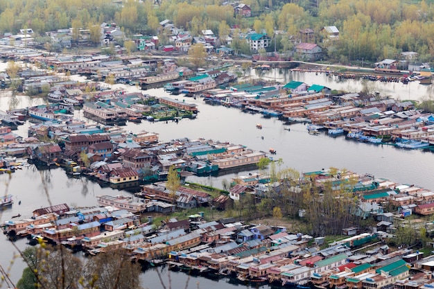  Lifestyle in Dal lake, man drive the boat in middle of the Dal lake and mountain backgrou