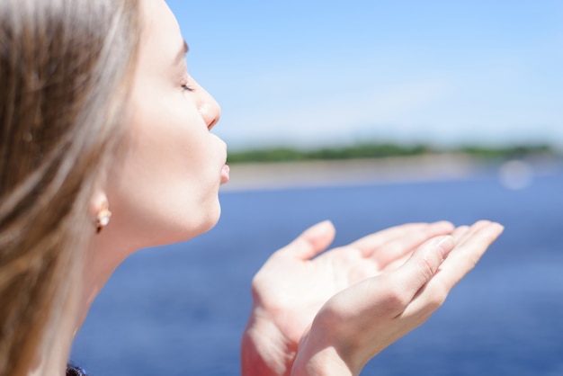 Photo lifestyle enjoying weather good sunny day sunbathing concept. cropped close up side half turned view photo portrait of pretty cute sweet beautiful lady sending air kiss to the ocean landscape