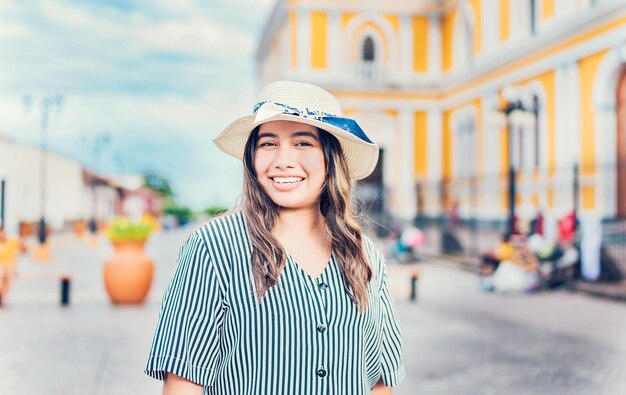 Lifestyle of happy traveler woman in a tourist square Portrait of smiling tourist girl on the streets of Granada Nicaragua