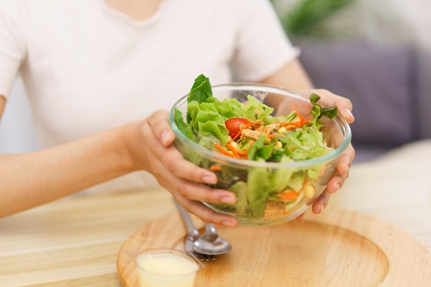 Lifestyle in living room concept Young Asian woman smiling and holding bowl of vegetable salad