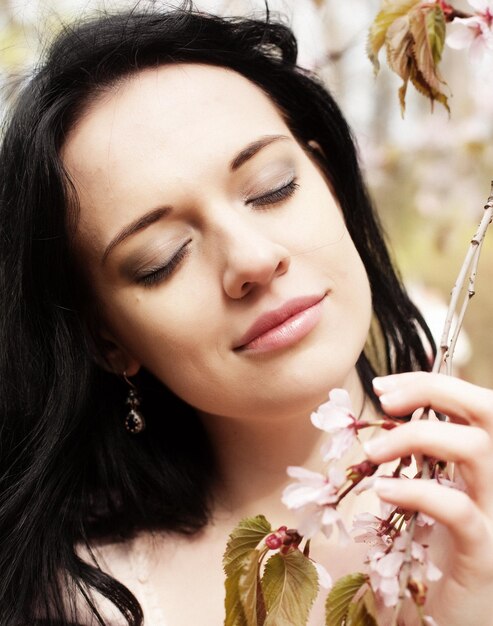 Lifestyle and people concept Beautiful young woman in blossom garden