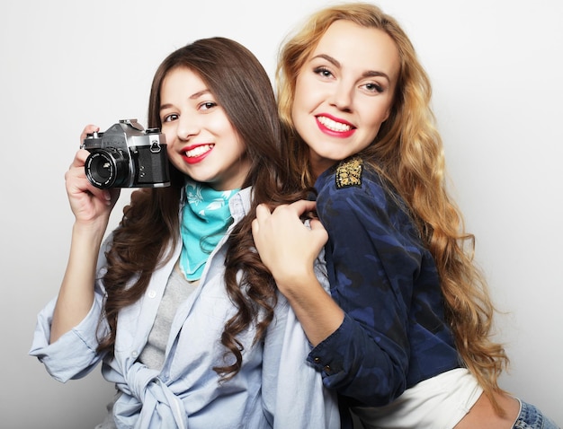 lifestyle and people concept Happy girls friends taking some pictures with camera over grey background