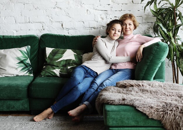 Lifestyle and people concept Senior Woman With Adult Daughter Relaxing On Sofa