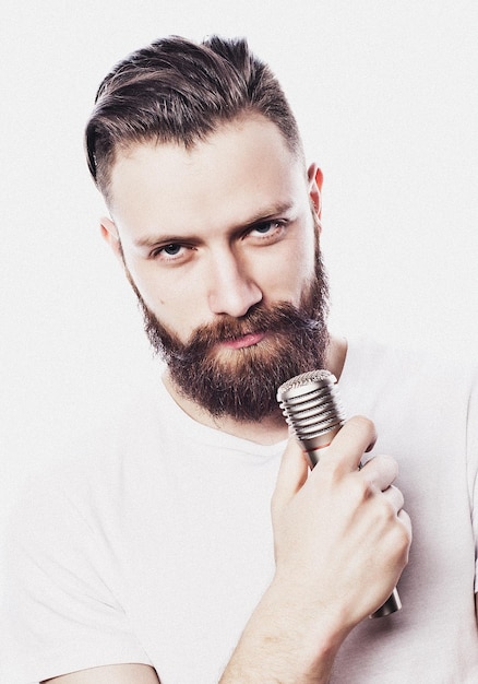 Lifestyle and people concept young bearded man singing with microphone