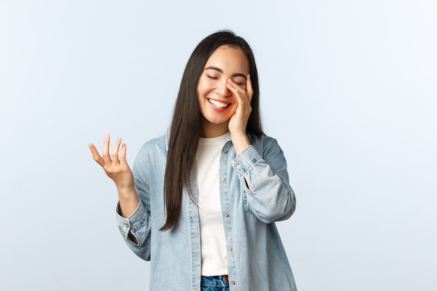 Lifestyle, people emotions and beauty concept. Carefree modern young asian teenage girl in casual clothes, laughing with closed eyes, look touched, talking, having friendly conversation.