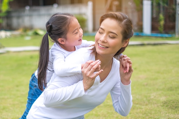 Lifestyle portrait asian mom and daughter in happines at the park