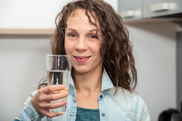 Lifestyle portrait of long haired beautiful girl drinking a wate