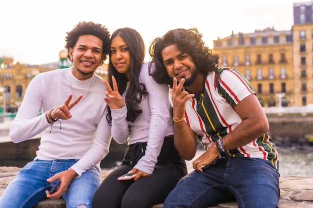 Lifestyle, portrait of three black friends having fun in the city with the sunset in the background