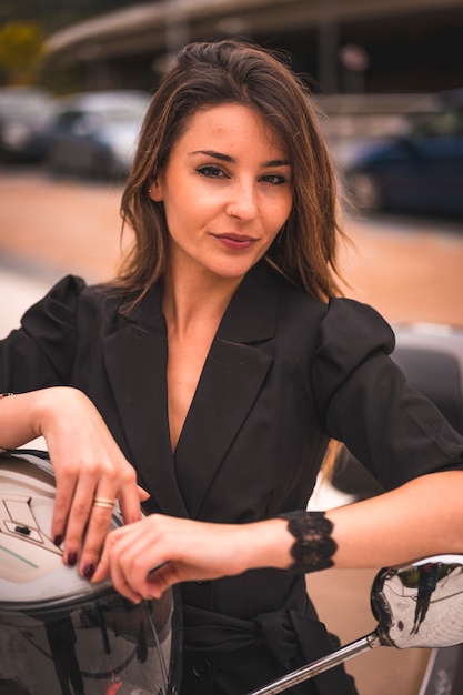 Lifestyle session on a motorcycle, a young blonde with a black blazer and white pants. Sitting on the bike