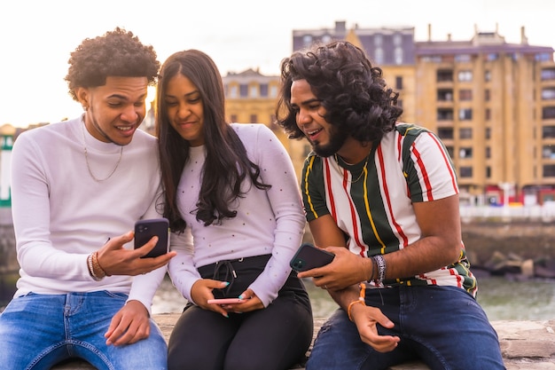 Lifestyle, three black friends having fun and watching social media on the street.