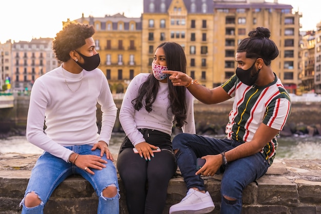 Lifestyle, three friends having a great time on the street with social responsibility with face masks.