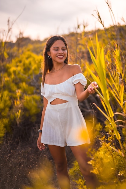 Lifestyle of a young brunette Caucasian enjoying the beach vacation in a white dress