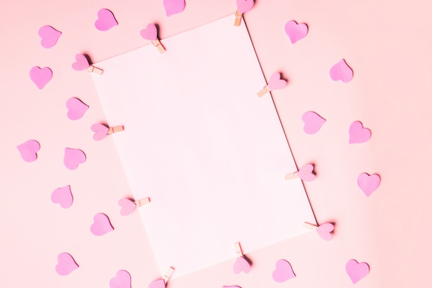 Light A4 paper for text and advertising on pastel pink background with hearts