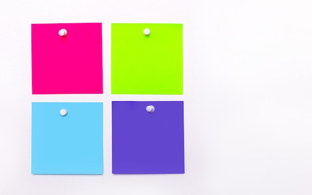 On a light background, four bright multi-colored stickers for notes. Copy space