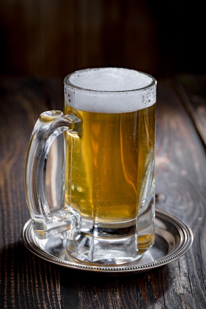 Light beer in a glass on an old background