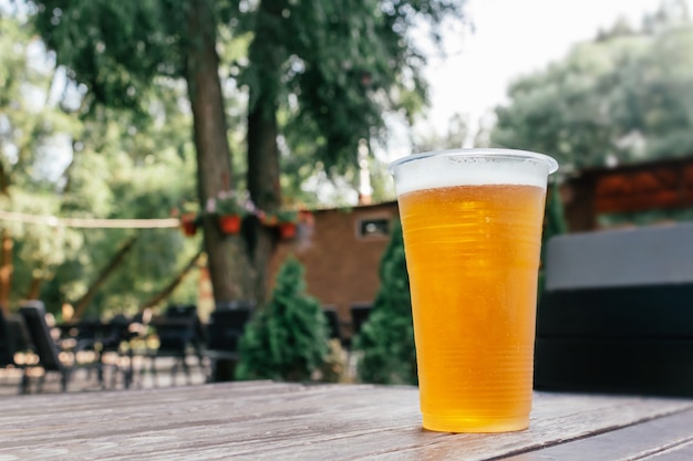 Light beer in glass on wooden table