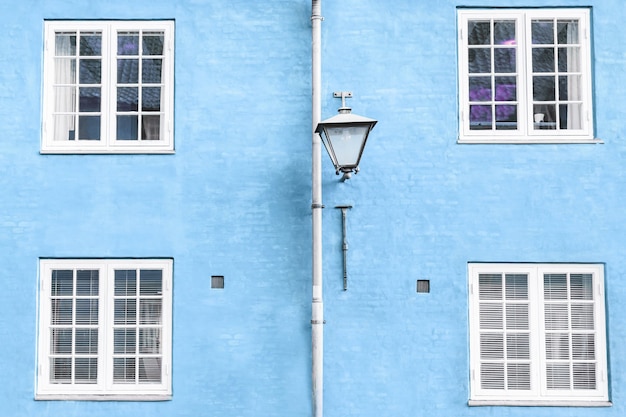 Light blue wall street lantern and four windows details fragment