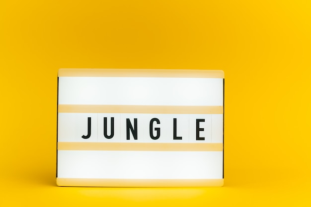 light box with text, JUNGLE, on yellow wall