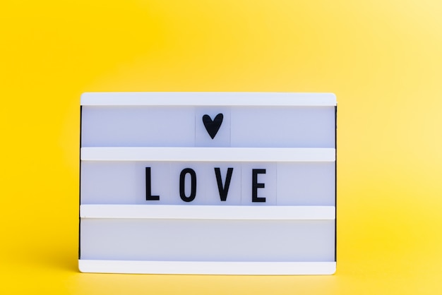 light box with text, LOVE, on yellow wall