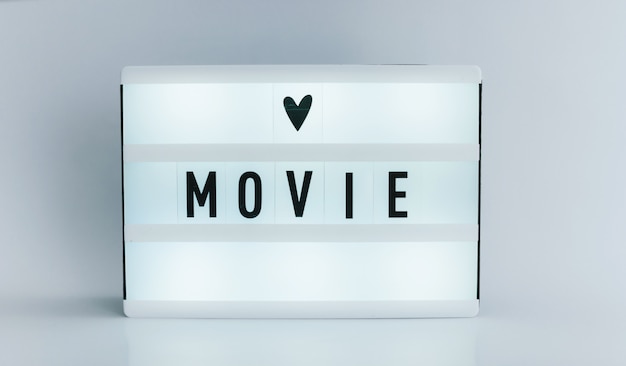 light box with text, MOVIE on white wall