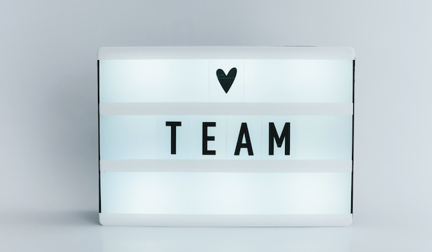 light box with text, TEAM on white wall