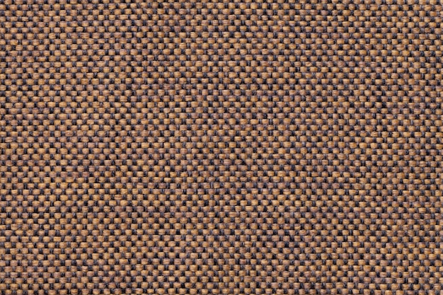 Light brown textile background with checkered pattern, closeup. Structure of the fabric macro.