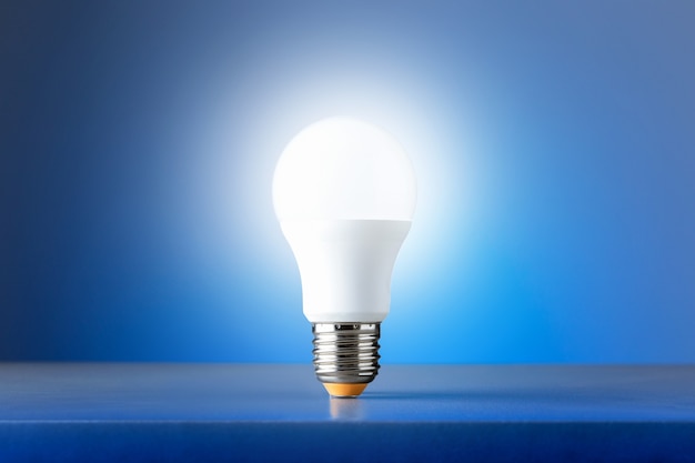 Light bulb on blue background. Concept of new ideas.