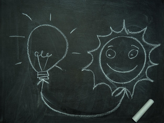 Light bulb in chalk on a blackboard and sun space for text solar energy concept