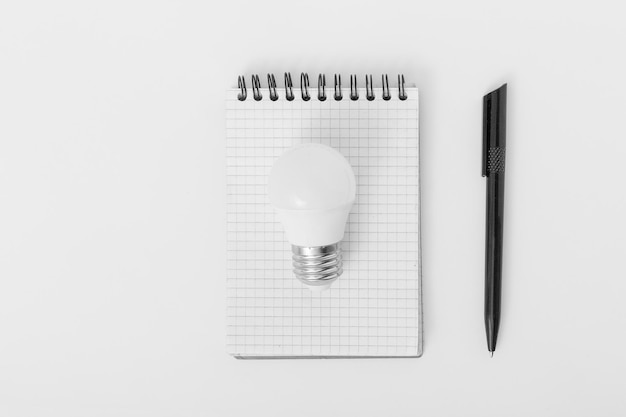 Light bulb notebook and pen on a white background Idea Concept