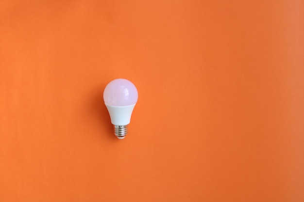 A light bulb on an orange background with a white lightbulb.